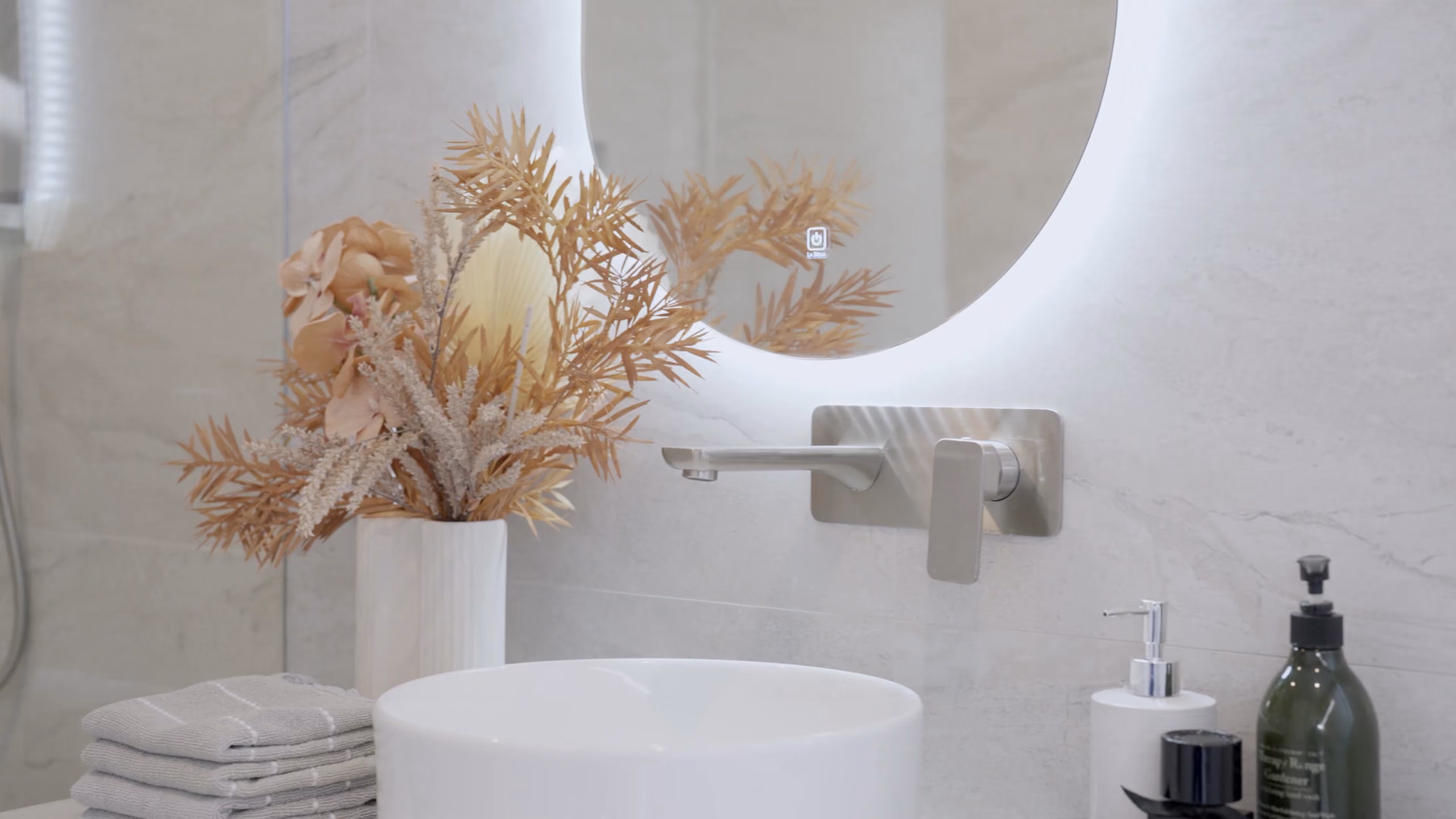 Longmere ensuite with a round mirror and stone vanity