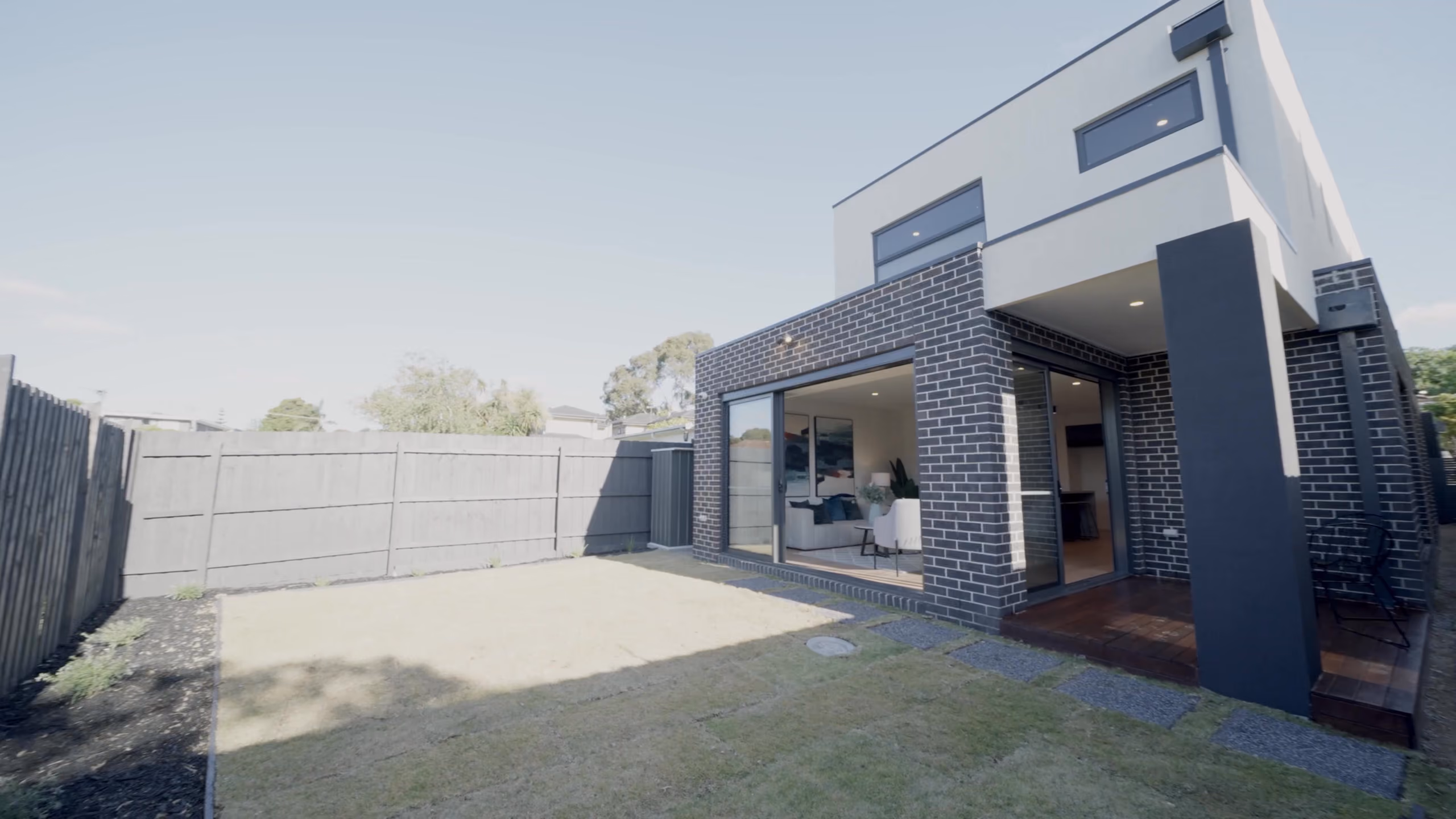 Longmere from the rear yard: brick and render with sliding doors to the deck