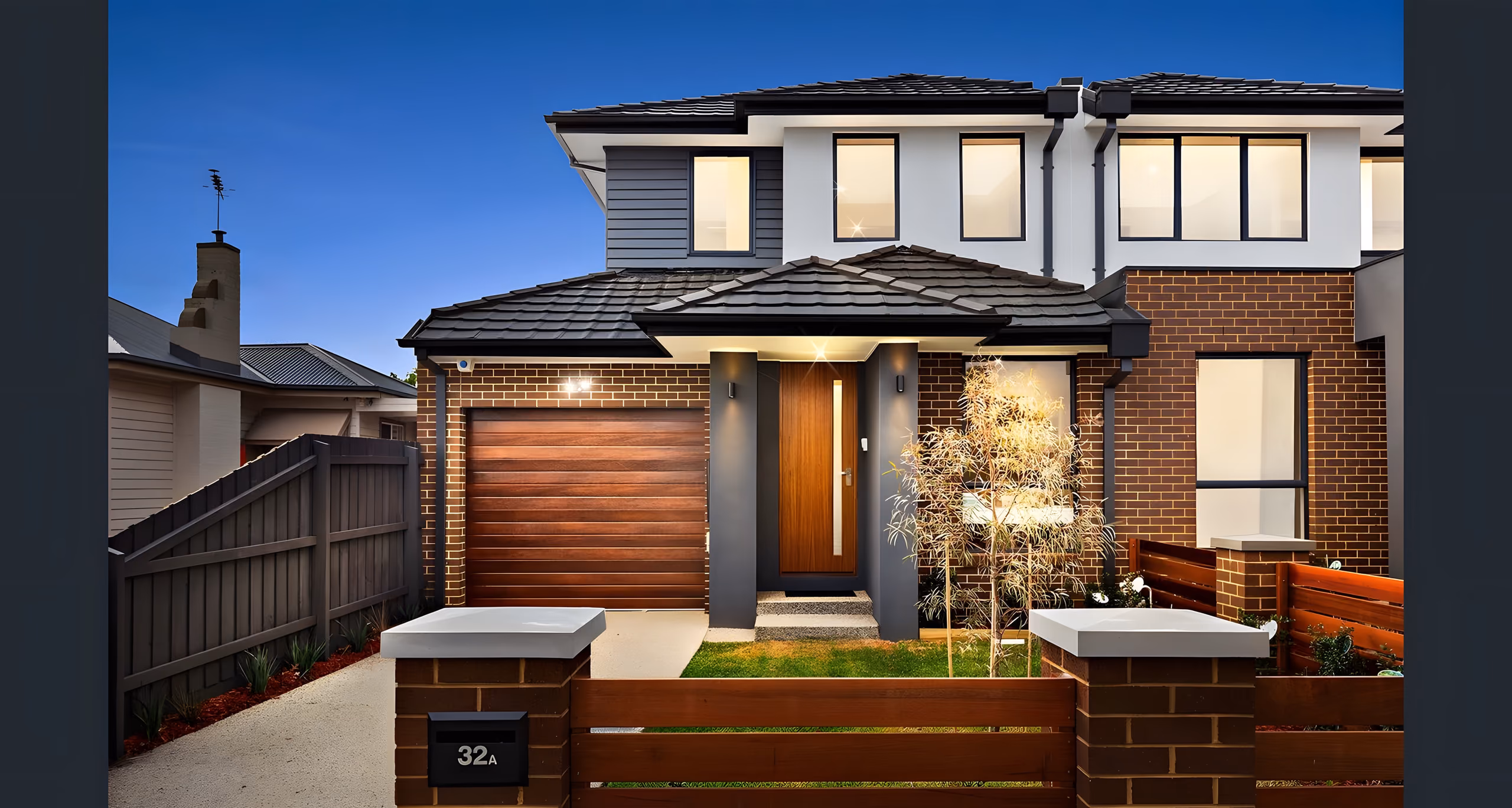 Leumear Street townhouse at dusk with a timber garage door