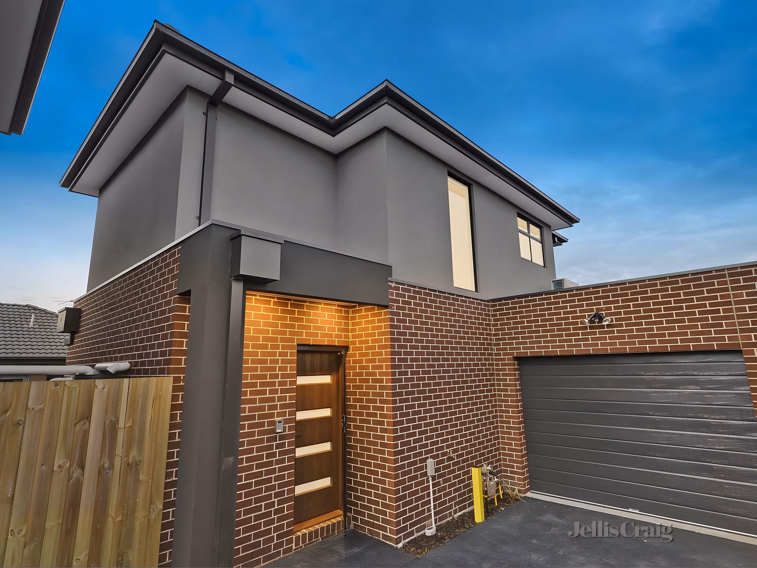 A front door Noble Ridge Homes built: dark brick, timber, a rendered upper storey